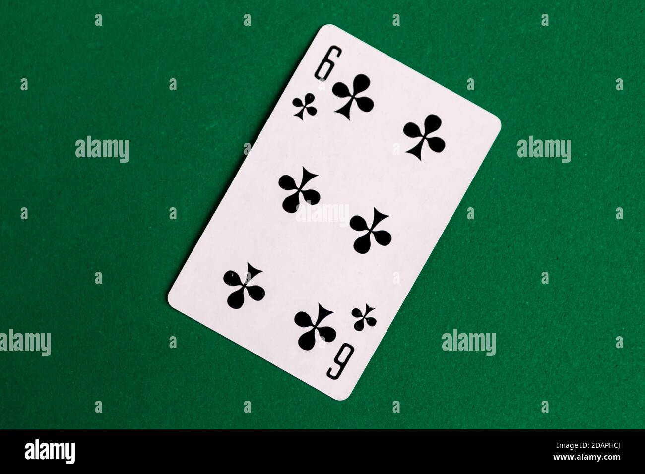 Six of Club playing card, green background Stock Photo - Alamy