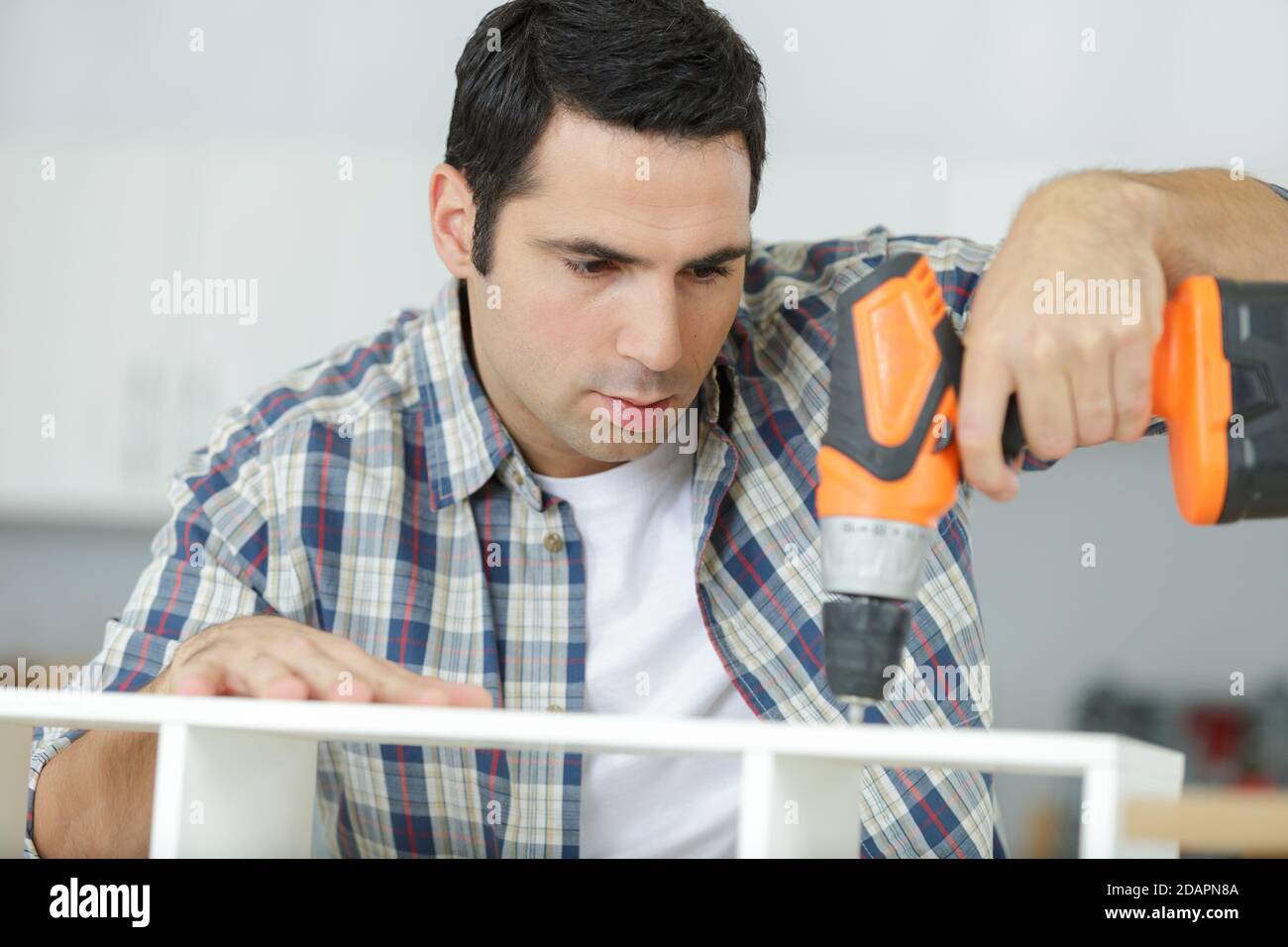 a man drilling wood plank Stock Photo