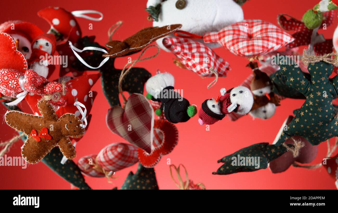 Flying christmas decorations on coloured background, concept of celebrating, studio shot. Stock Photo