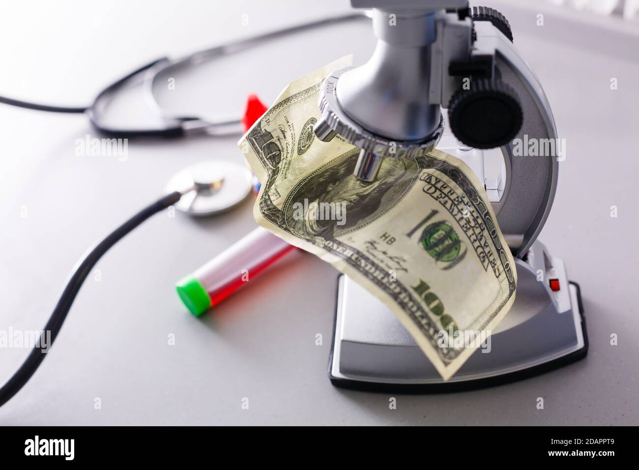 Microscope examining dollar strength on a white background Stock Photo