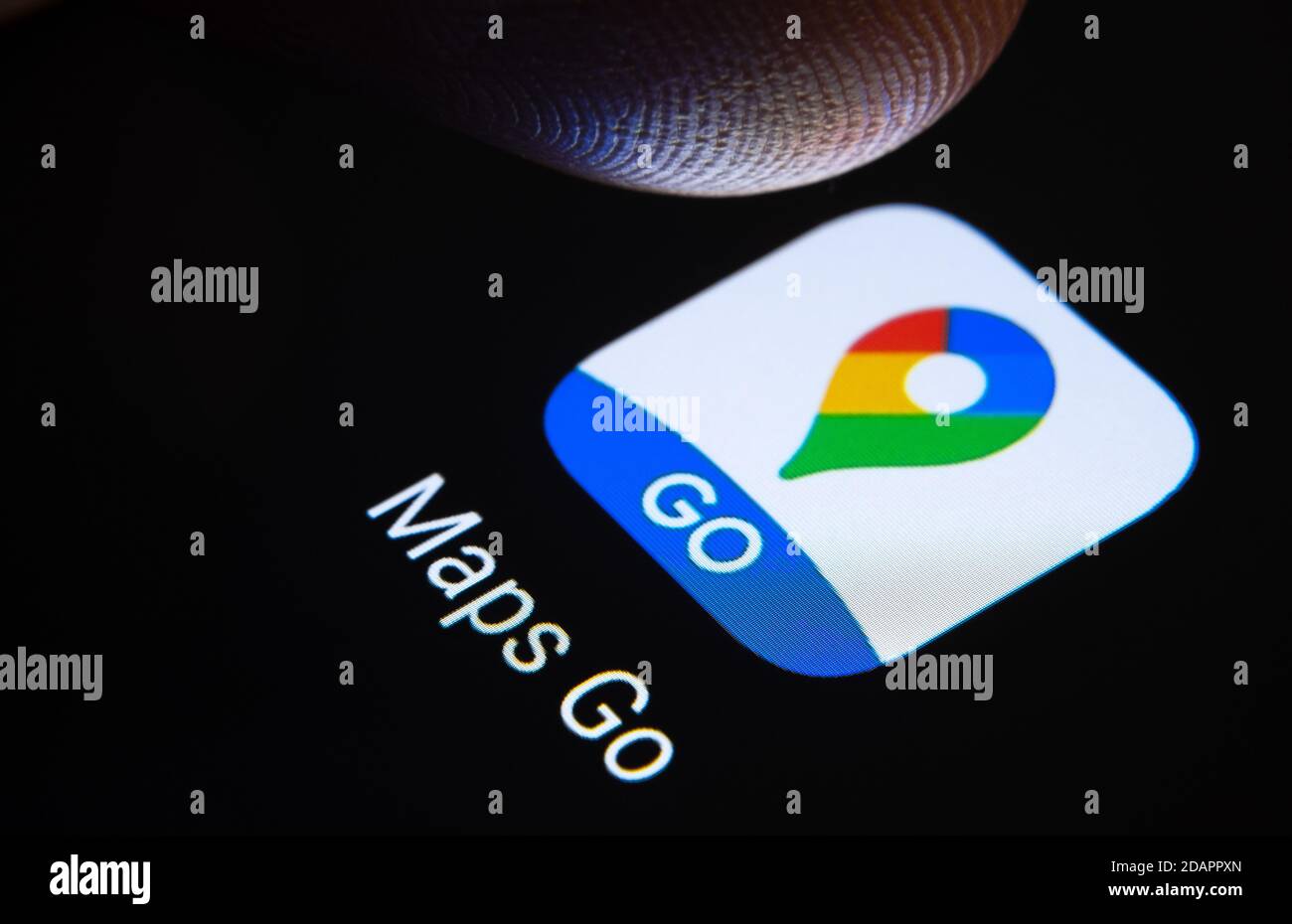 Stafford / United Kingdom - November 12 2020: Google Maps Go app and blurred finger tip above it ready to press the screen of smartphone. Stock Photo