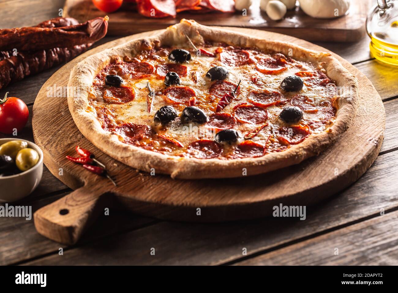 Pizza diavola traditional italian meal with spicy salami peperoni chili and olives Stock Photo