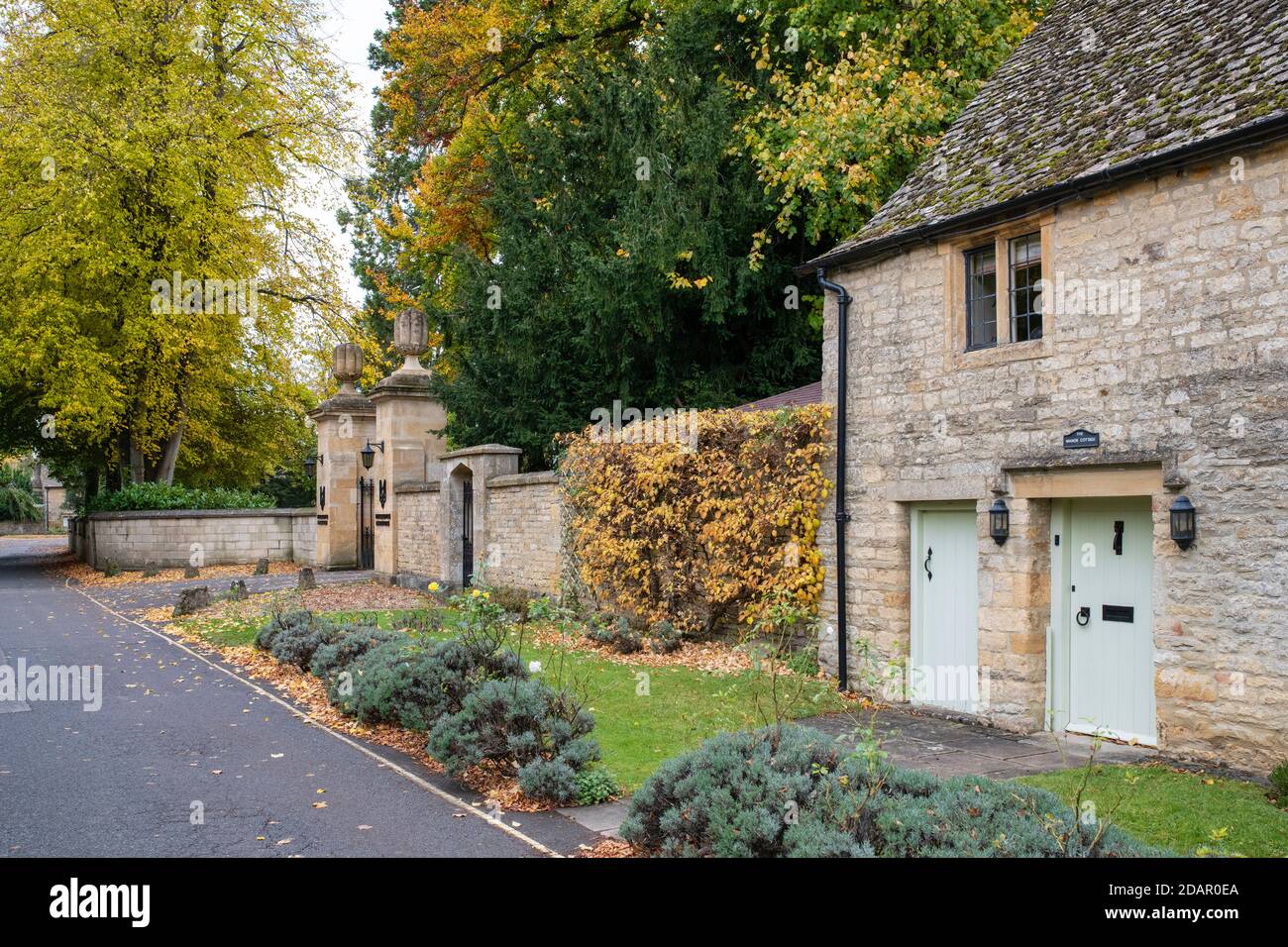 Cotswold stone cottage and the entrance to The Slaughtes Manor House in autumn. Lower Slaughter. Cotswolds, Gloucestershire, England Stock Photo