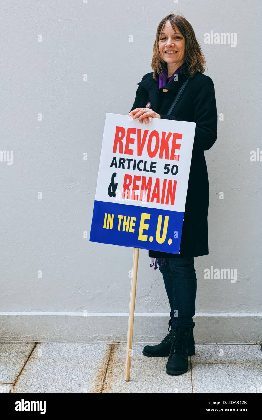 LONDON, UK - A anti-brexit protester holds a' Revoke article 50 and remain 'placard during Anti Brexit protest on March 23, 2019 in London. Stock Photo