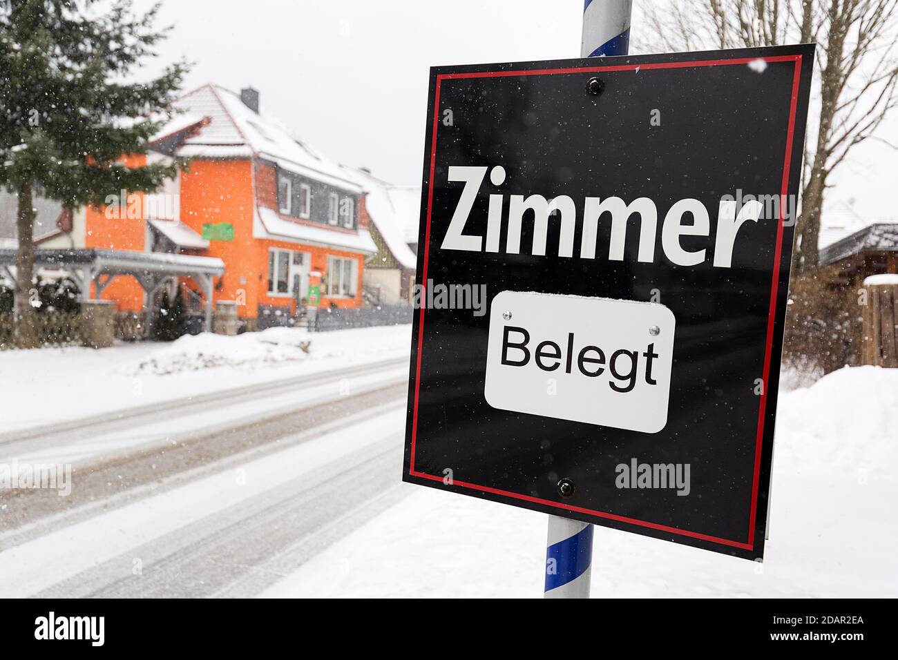 Black sign with the inscription Zimmer belegt, dreary winter weather, district Schierke, Wernigerode, Harz County, Saxony-Anhalt, Germany Stock Photo