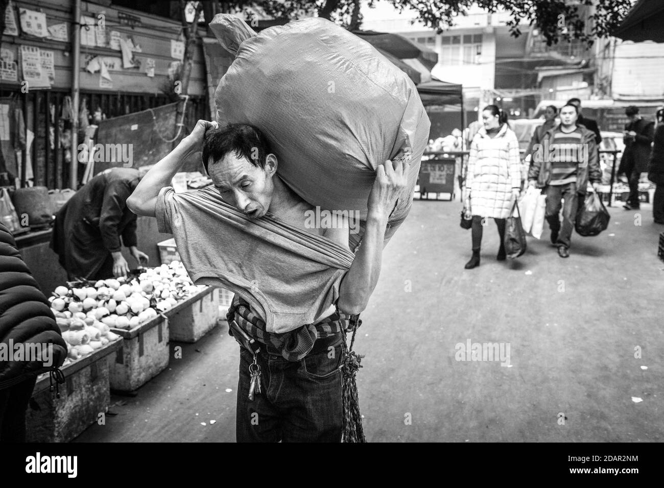Bang-bang carriers in a market at the port of Chongqing, the carriers are like a caste of their own, carrying loads for the traders for little money Stock Photo