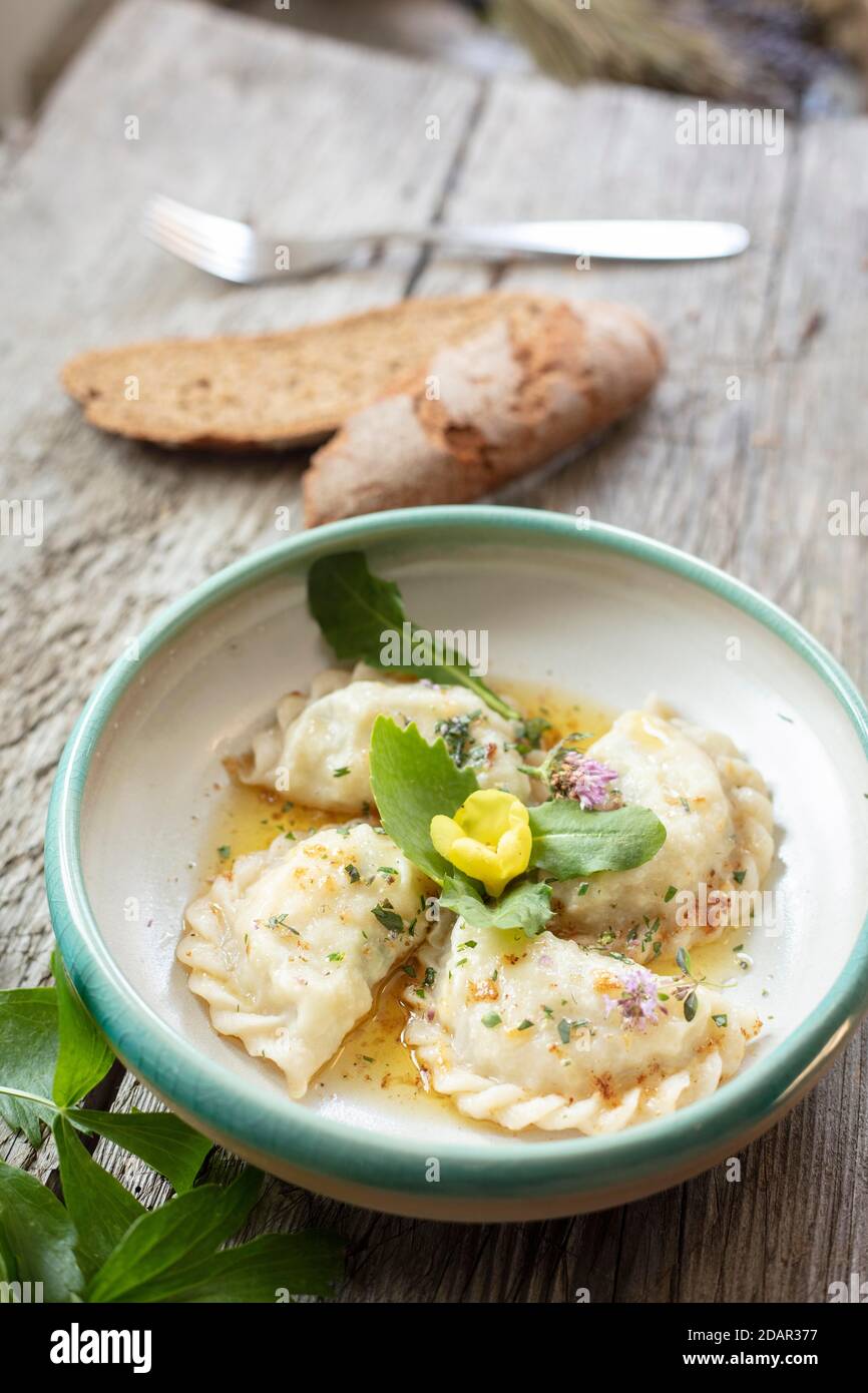 Carinthian noodles filled with herbs and cream cheese, melted butter, bread and lovage, Irschen, Carinthia, Austria Stock Photo