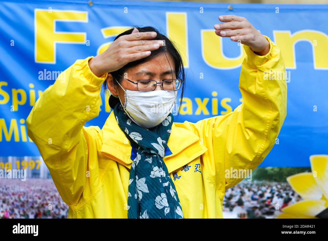 Dortmund, Germany, 14th. Nov. 2020: A woman practicing Falun Gong meditation with face mask during a protest against persecution of Falun Gong followers in China Stock Photo