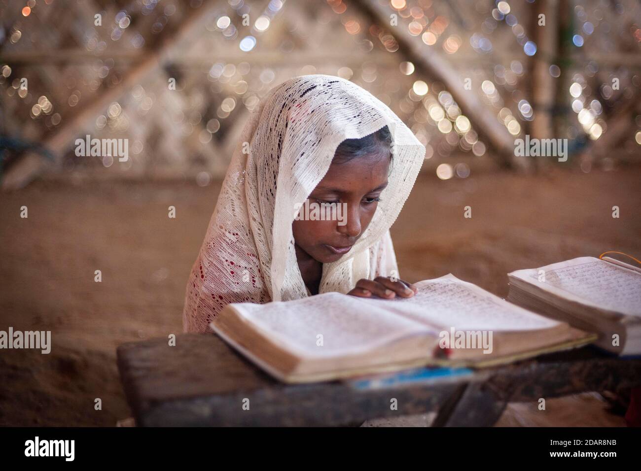 Girl reading in a madrasah, Koran school, camp for Rohingya refugees ...