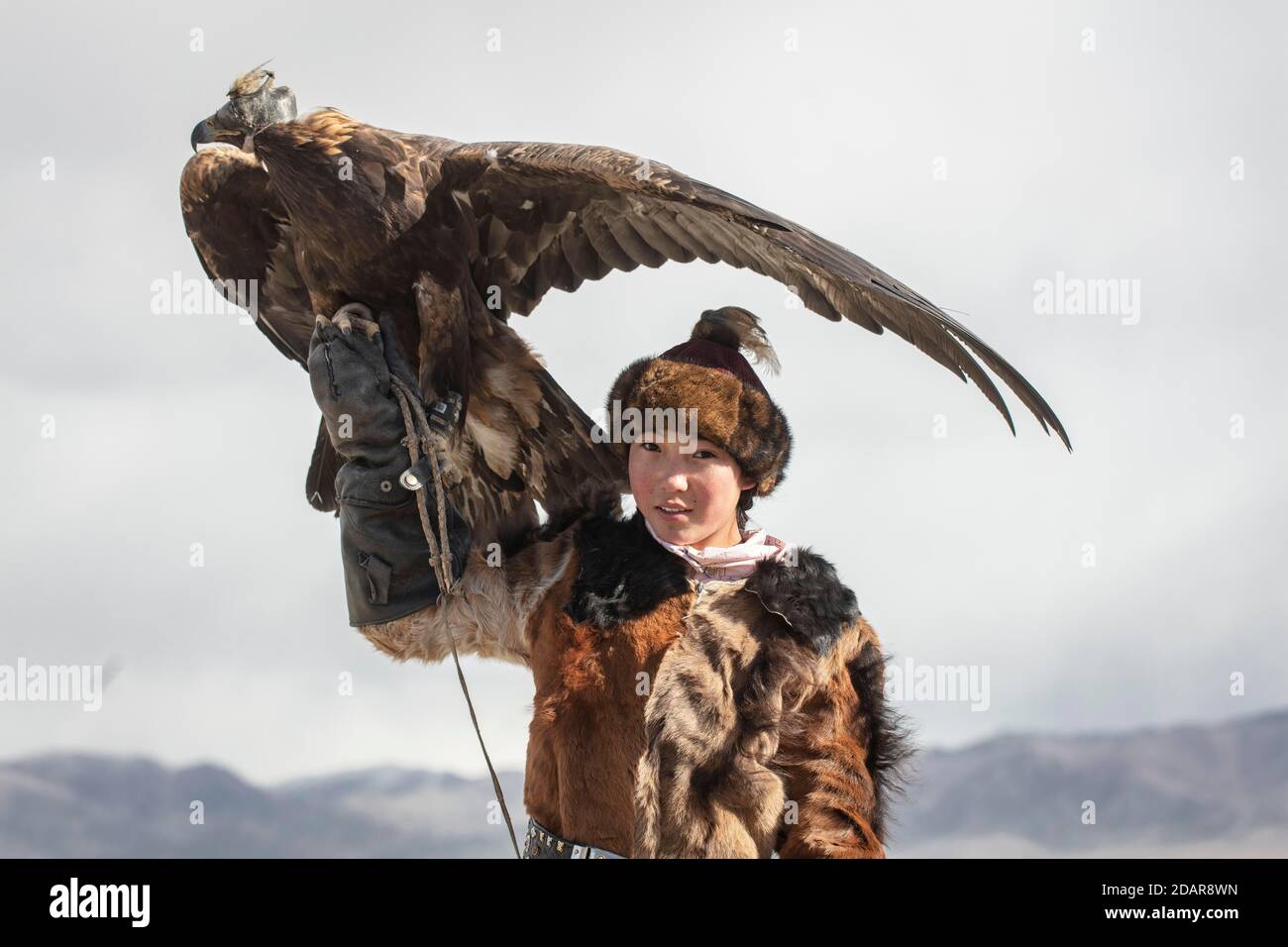 Young eagle hunter with her female eagle, Olgii, Mongolia Stock Photo