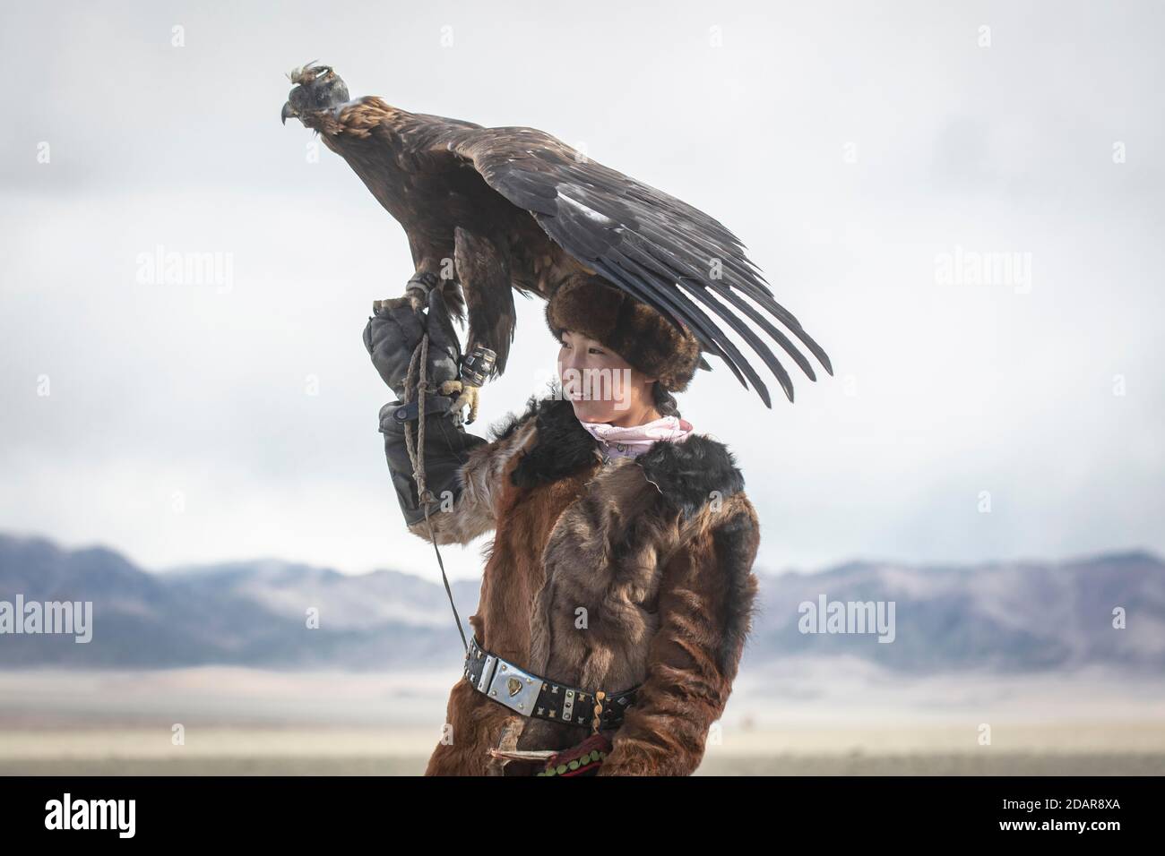 Young eagle hunter with her female eagle, Olgii, Mongolia Stock Photo