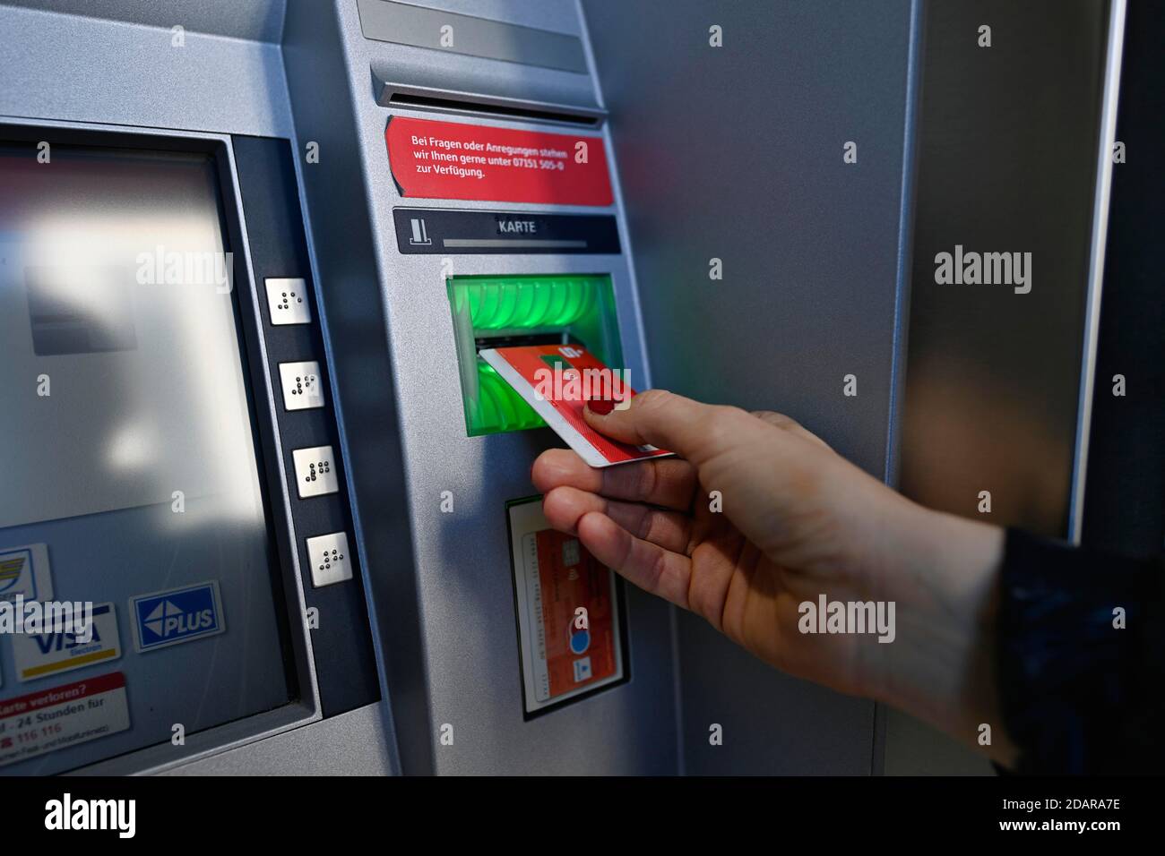 Woman introduces ec-card at the cash dispenser of a savings bank, Waiblingen, Baden-Wuerttemberg, Germany Stock Photo