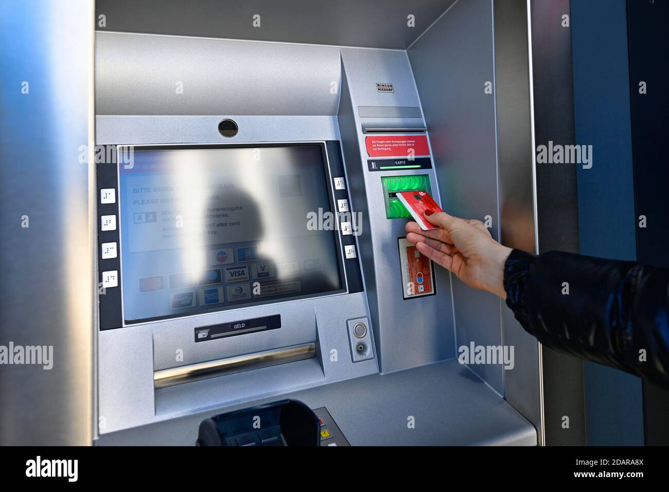 Woman introduces ec-card at the cash dispenser of a savings bank, Waiblingen, Baden-Wuerttemberg, Germany Stock Photo