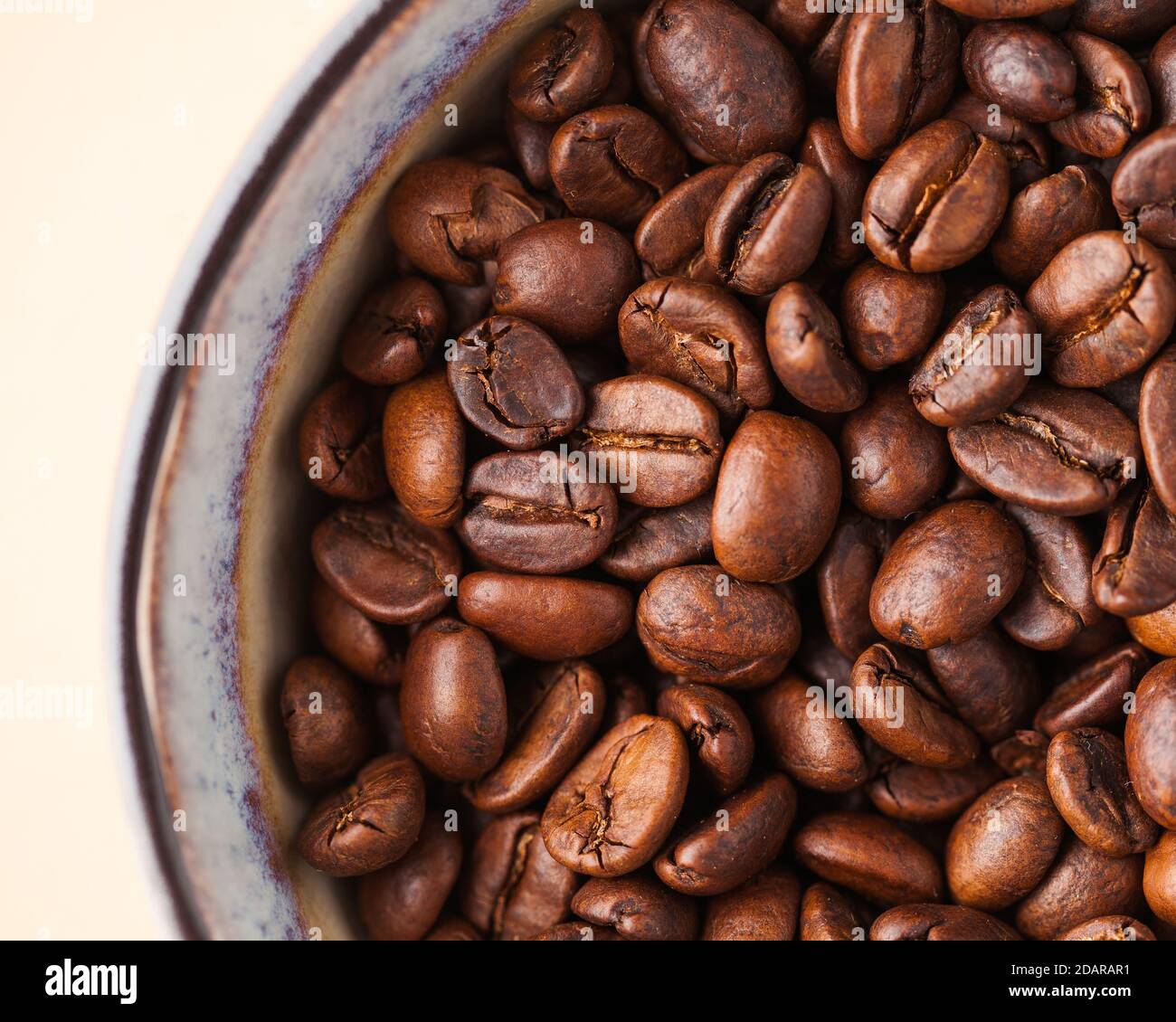 Coffee beans close-up on a light brown background. For screensavers, roasters and coffee sellers. Stock Photo