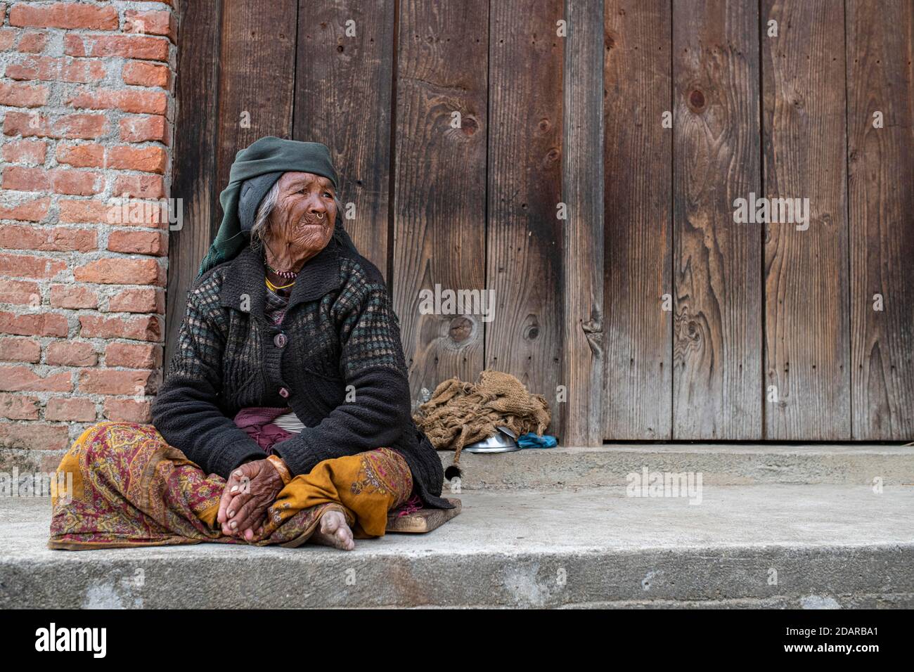 Elderly woman with headscarf and nose ring sitting in front of a wooden  door, Himalaya, Jiri, Khumbu region, Nepal Stock Photo - Alamy