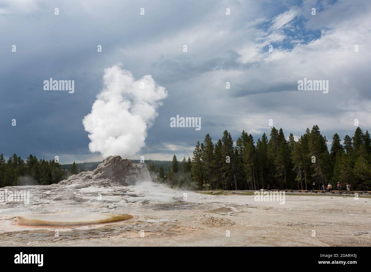Castle Geyser emits a steam plume as visitors watch from a distance in Yellowstone National Park, Wyoming on Monday, August 3, 2020. The park recently Stock Photo