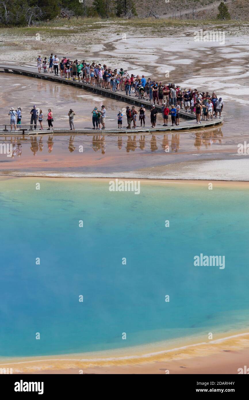 Visitors walk along the boardwalk at Grand Prismatic Spring in Yellowstone National Park, Wyoming on Monday, August 3, 2020. Many of the parks boardwa Stock Photo