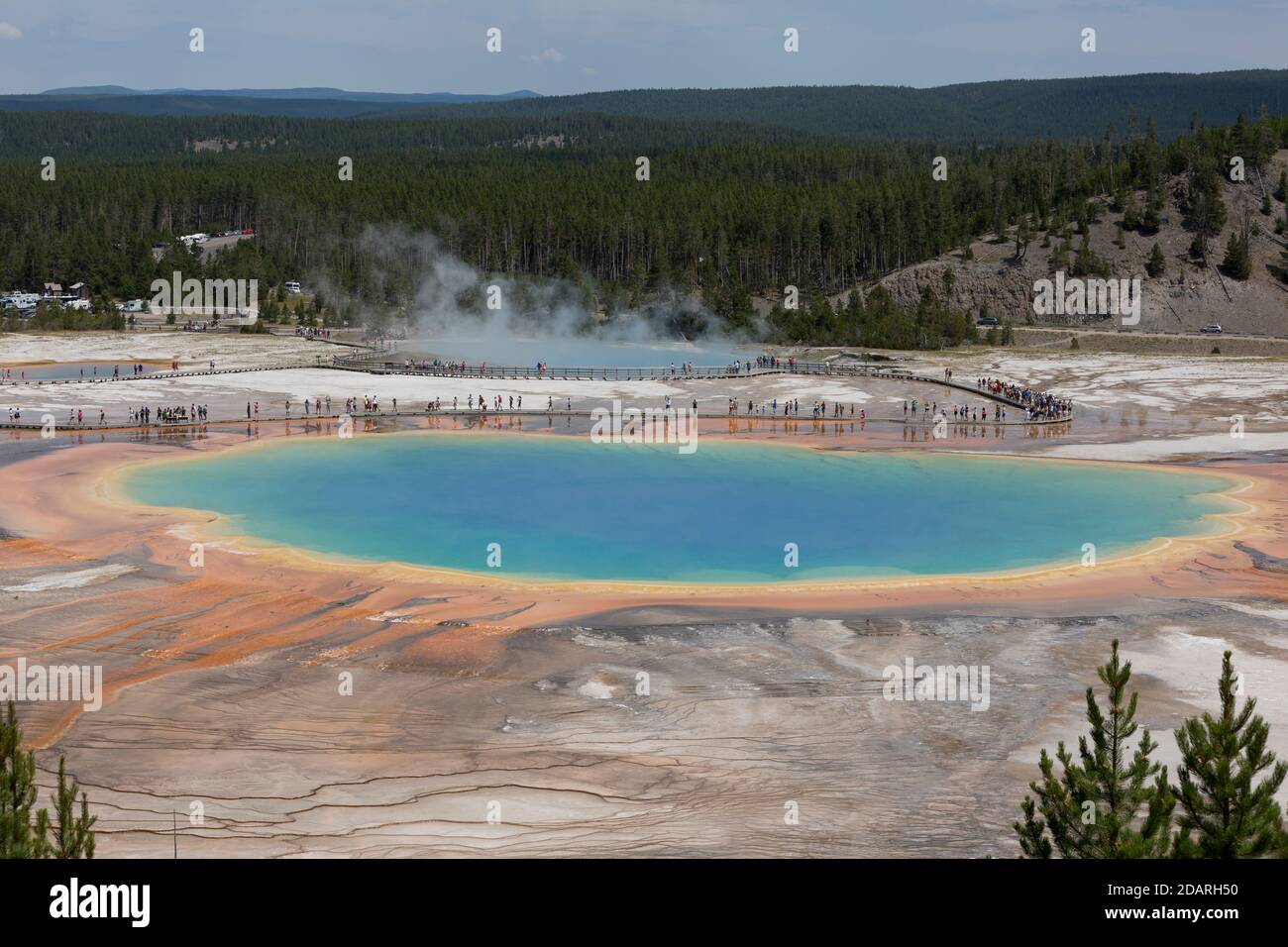 Visitors cue up along the boardwalk at Grand Prismatic Spring in Yellowstone National Park, Wyoming on Monday, August 3, 2020. Many of the parks board Stock Photo
