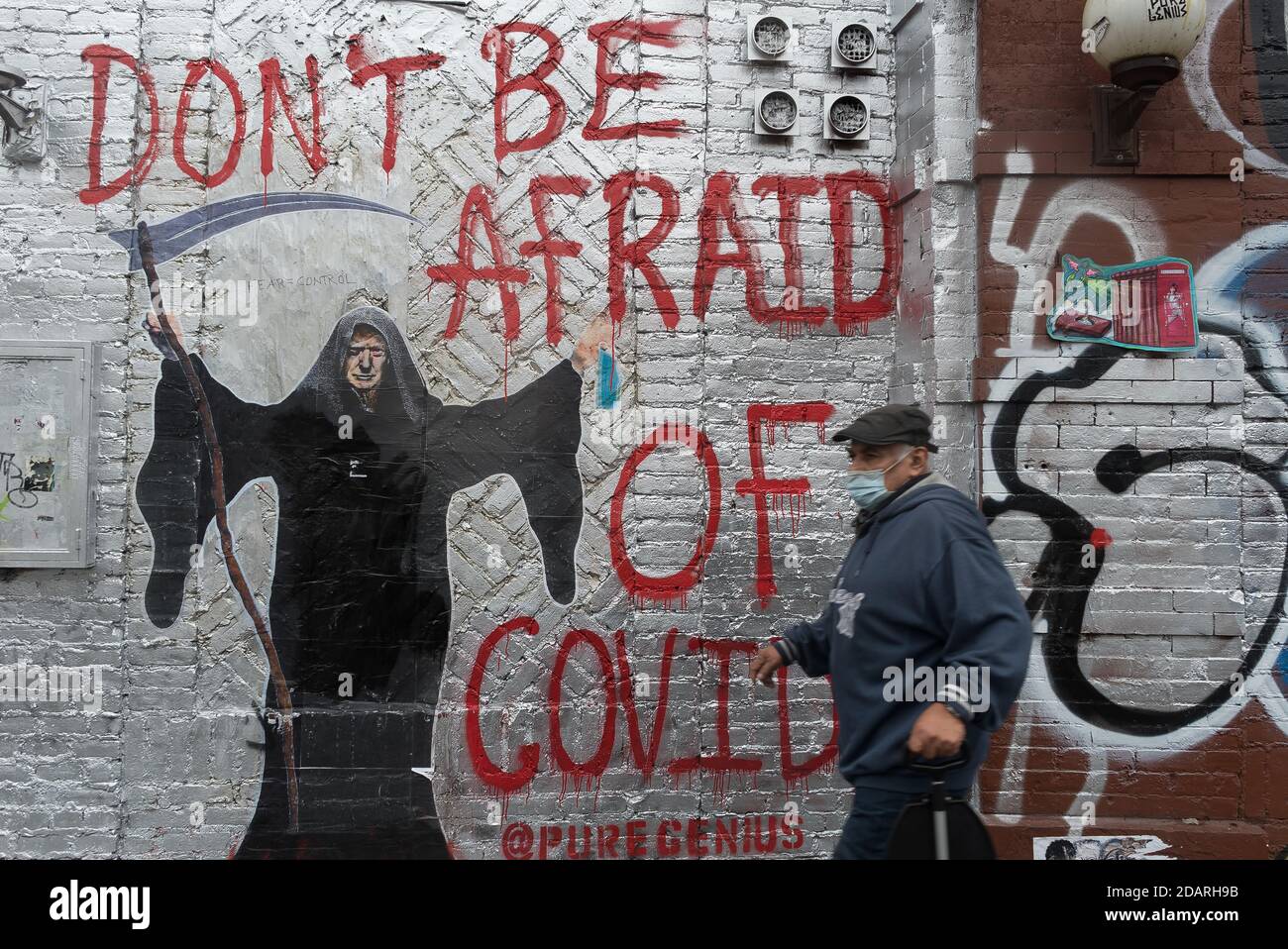 Manhattan, New York. November 13, 2020. A man wearing a mask walks in