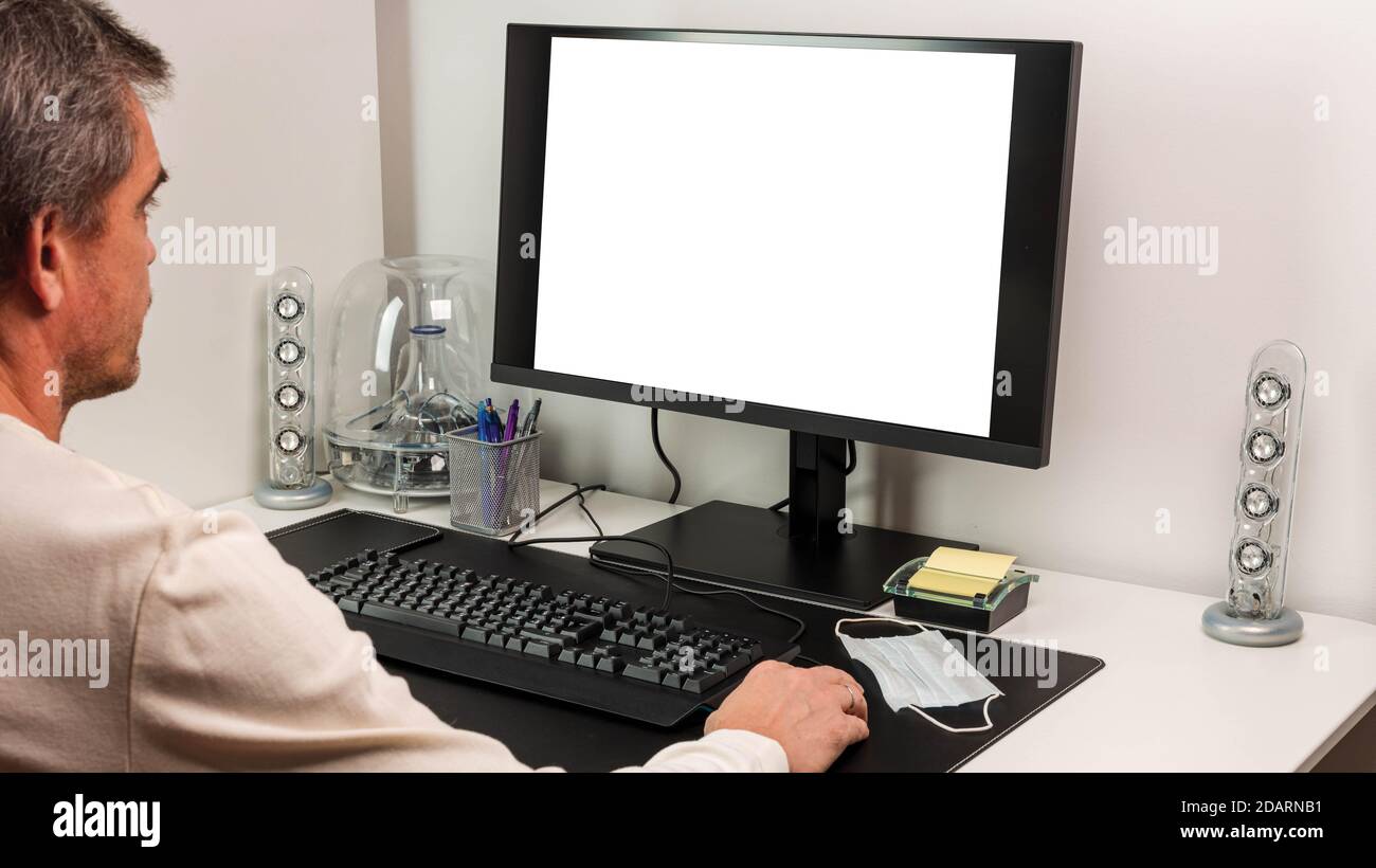 View of man using computer monitor with mockup image blank screen with ...