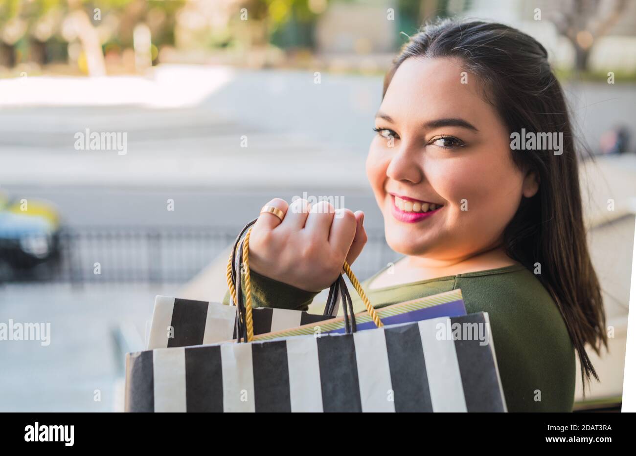 Young woman holding shopping bags at mall Stock Photo - Alamy