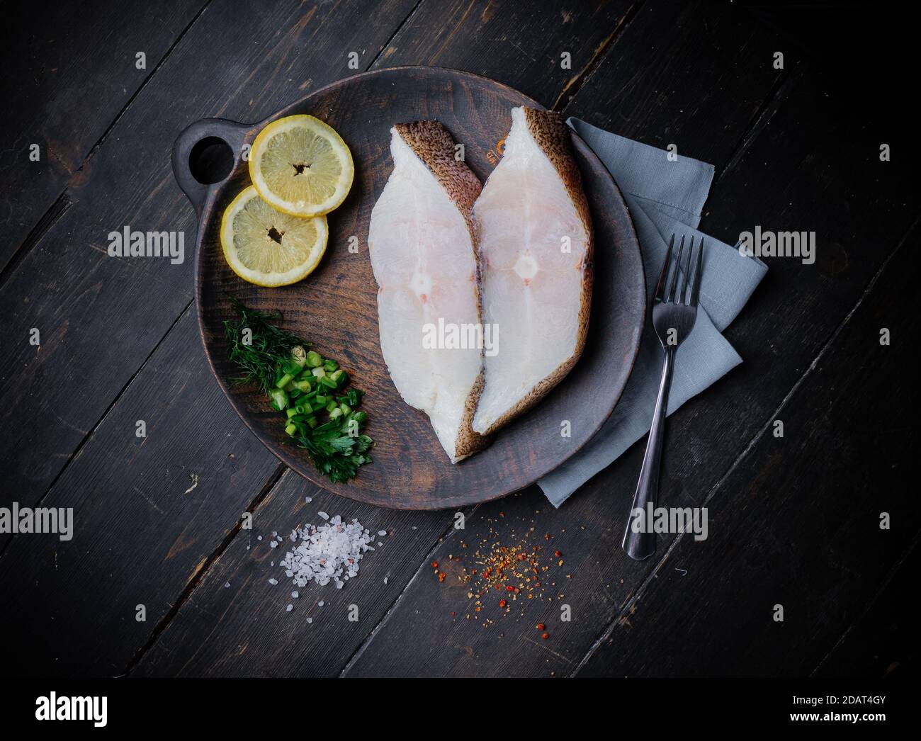 Frozen Greenland halibut steaks on the wood cutting board. Food