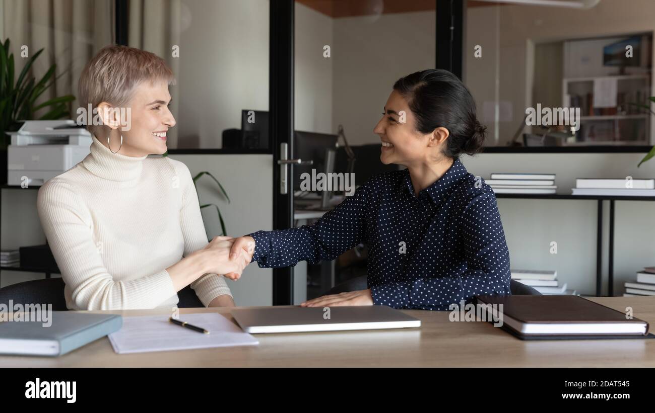 Smiling diverse business partners colleagues shaking hands at meeting Stock Photo