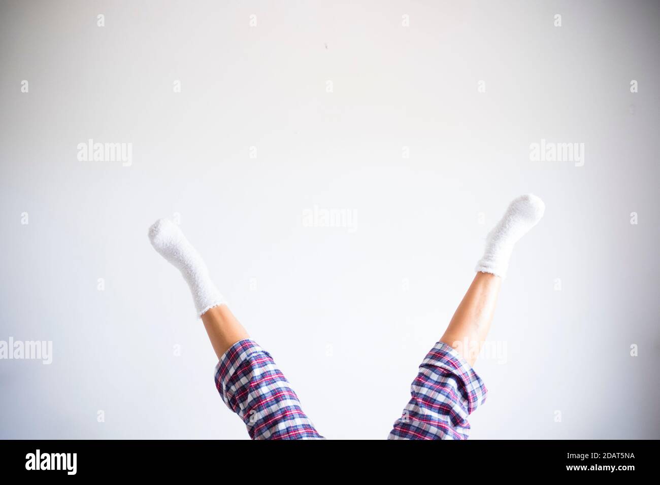 Woman legs down up reverse position with white room wall background - concept of fitness exercises at home and healthy funny lifestyle people - copysp Stock Photo