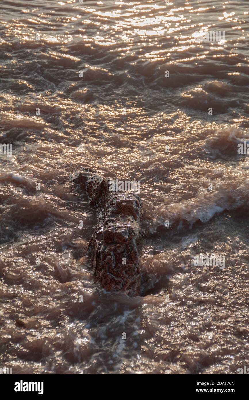 Waves lapping road the pebbles on the beach Stock Photo