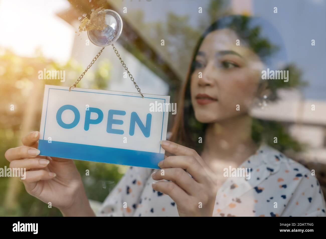 young woman owner turning open sign in door of store Stock Photo Alamy