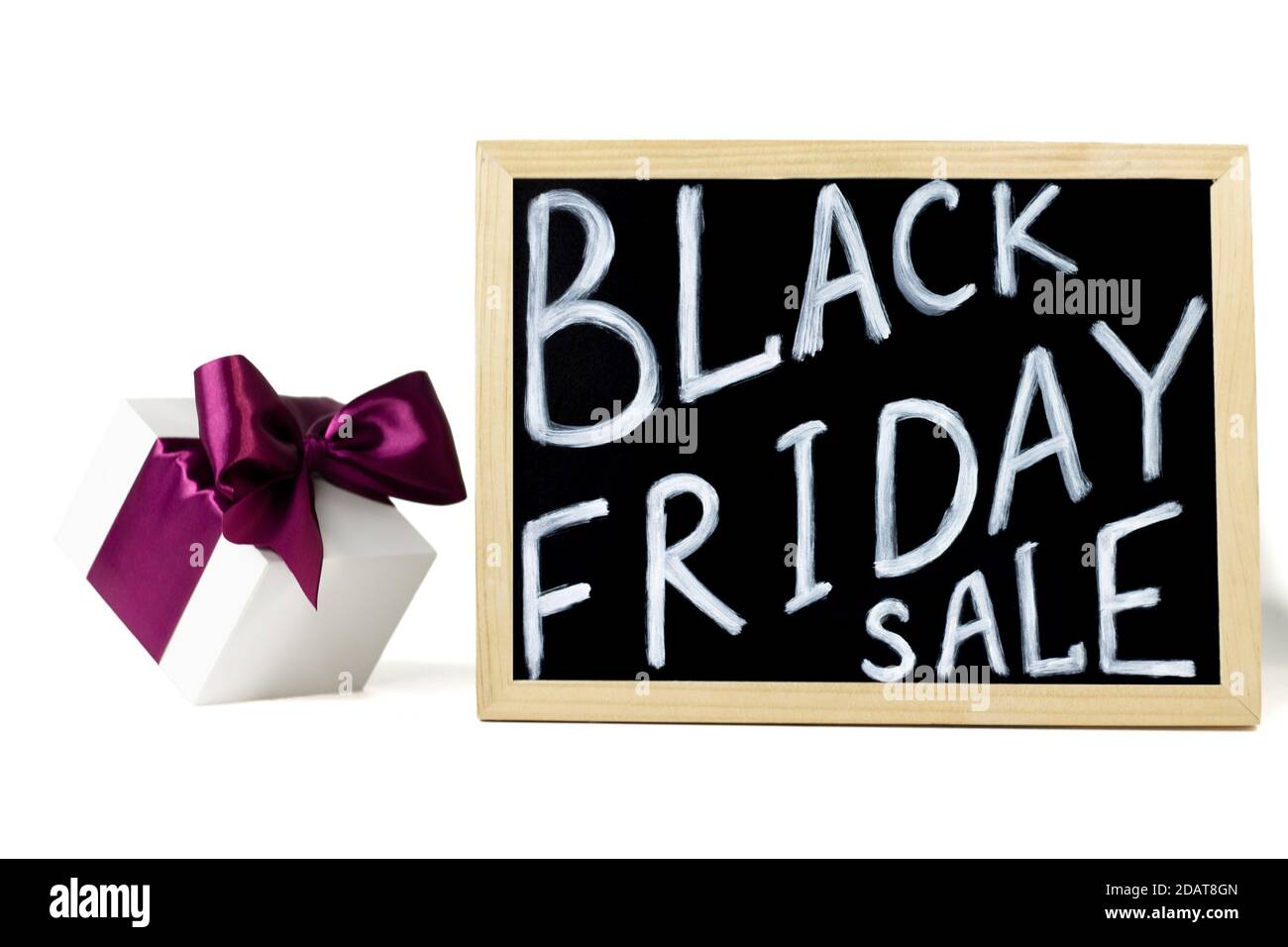 White gift box with lilac ribbon next to Black Friday Sale sign, on white background Stock Photo