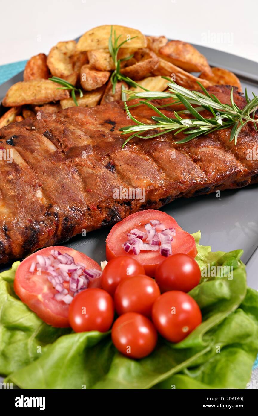 pork spare ribs and salad at plate Stock Photo