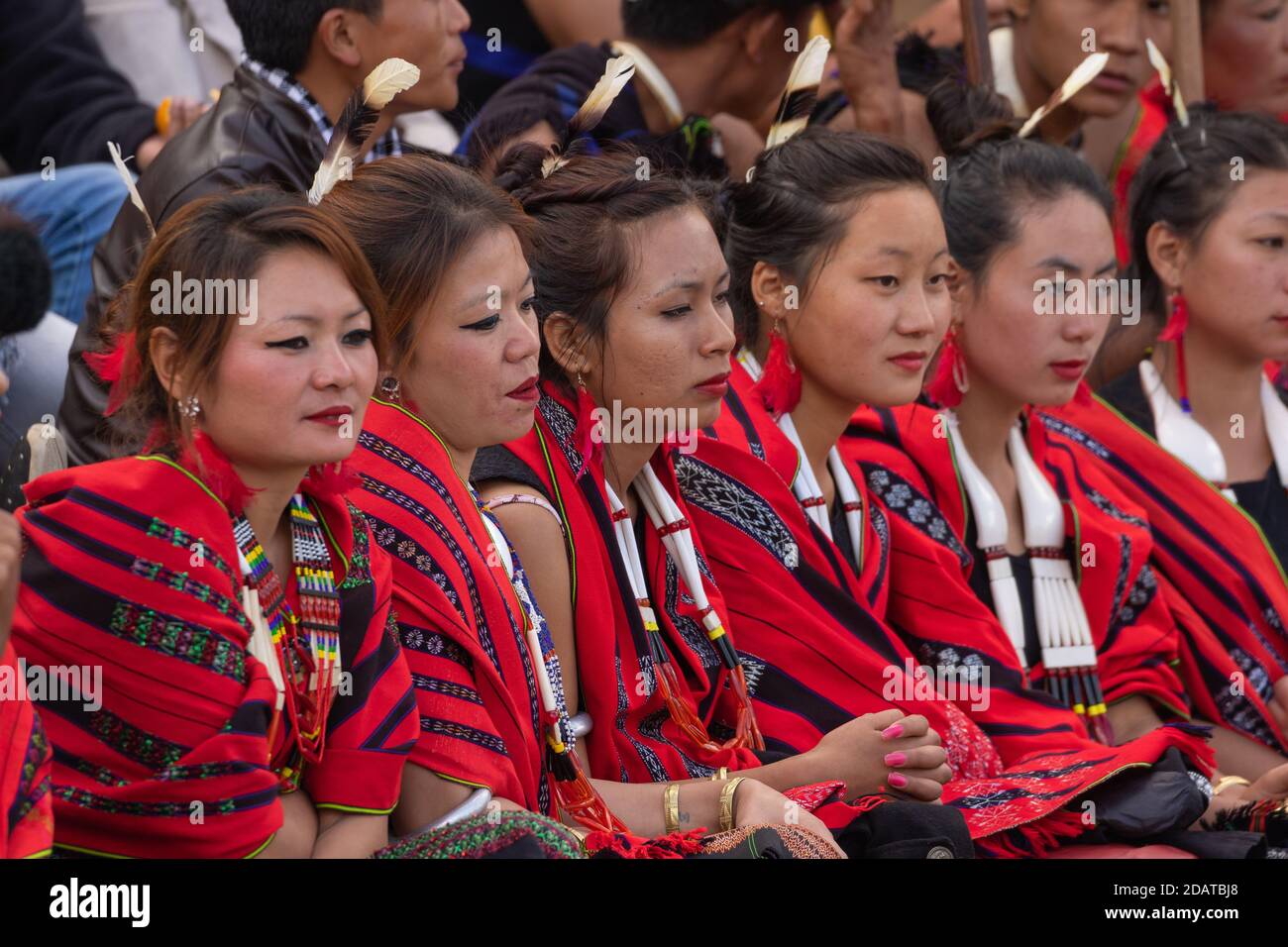 Young Naga tribeswomen siting together wearing colorful attire and shawls in Kisama Heritage village in Nagaland India on 3 December 2016 Stock Photo