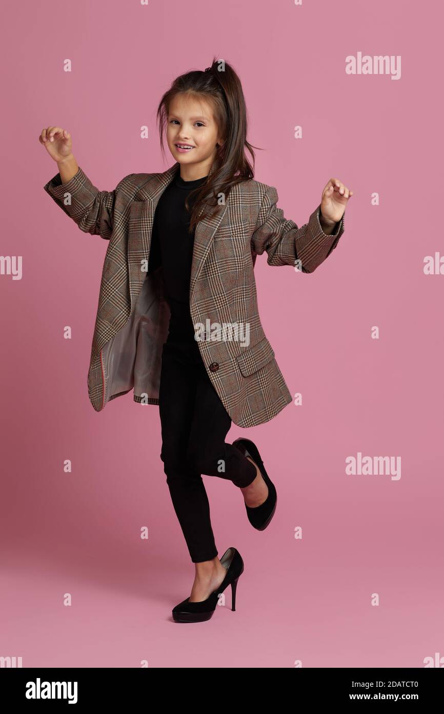 funny little child girl in white oversized mother's jacket and shoes on