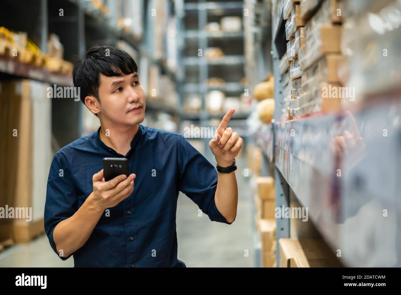 man worker using smartphone to checking inventory in the warehouse ...
