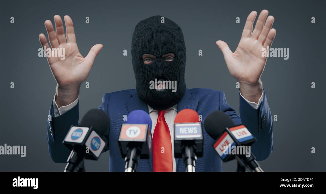 Criminal politician wearing a balaclava and talking to the media, he is