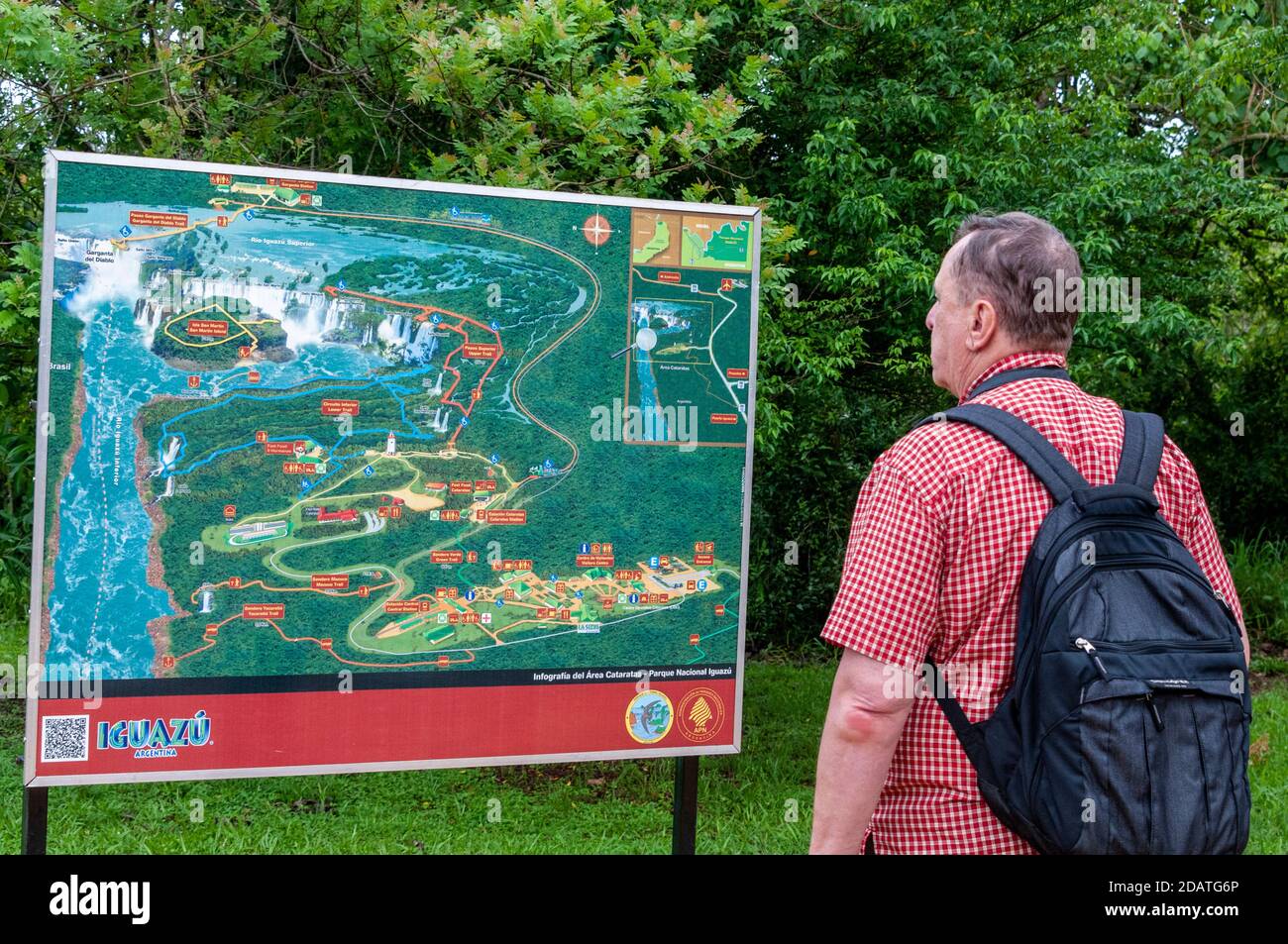 A visitor studies the large map of the waterfall locations and foot trails in the Iguazu National Park in Argentine.  The Iguazu Waterfalls is the Stock Photo