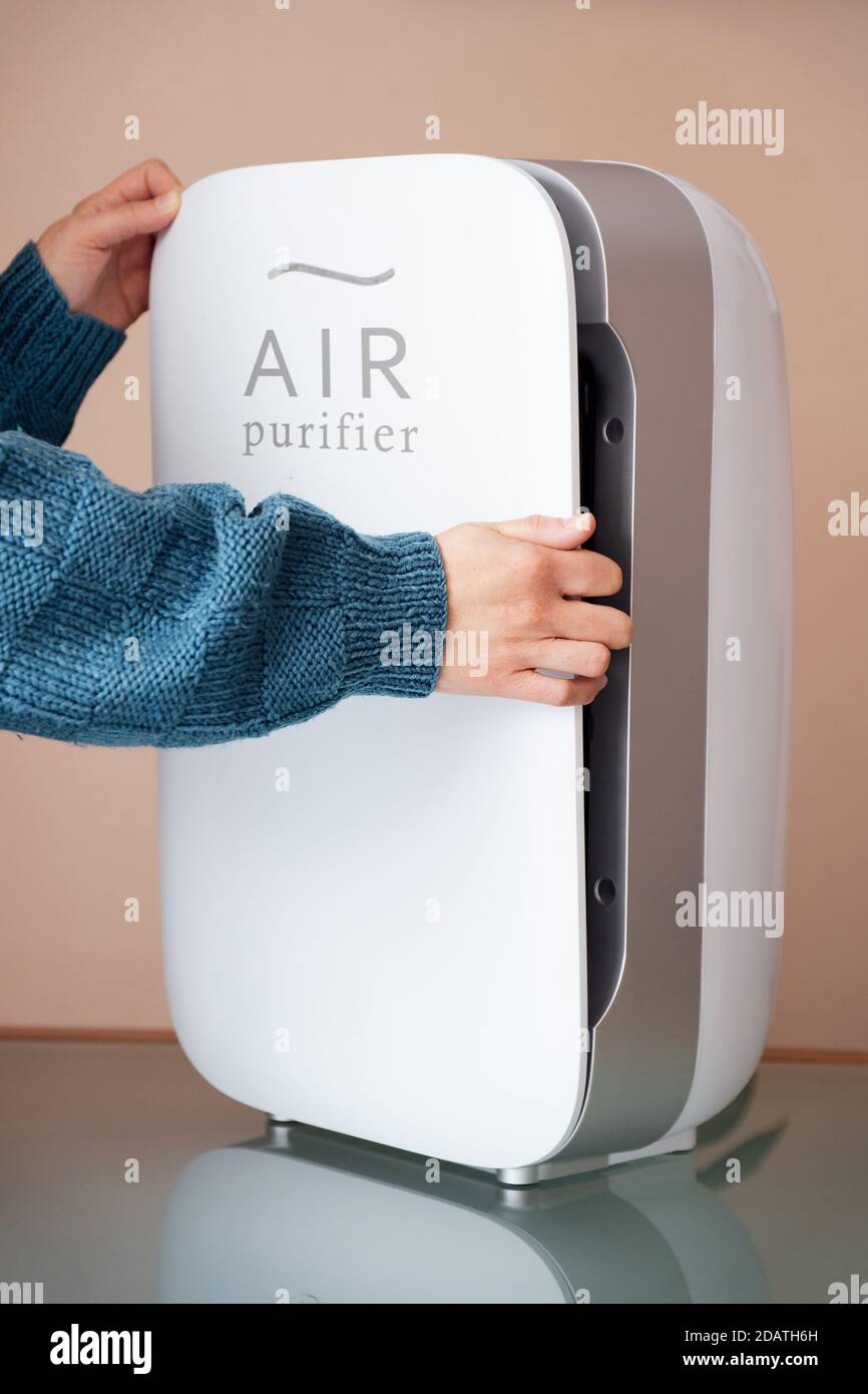 Hands changing air, dust, carbon and hepa purifier filters Stock Photo