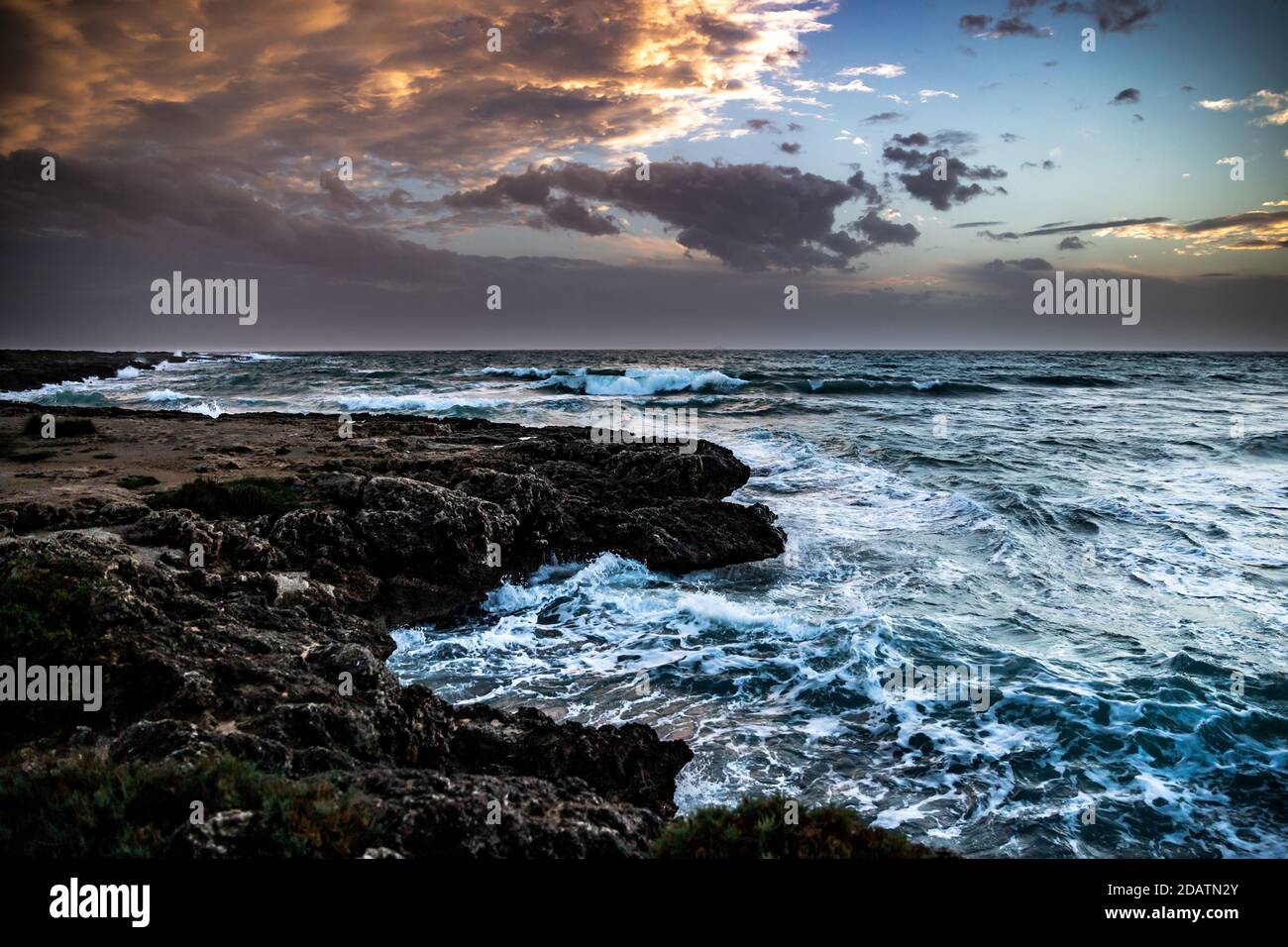 Landscape of waves tossing in the rocks in Italy during sunset Stock ...