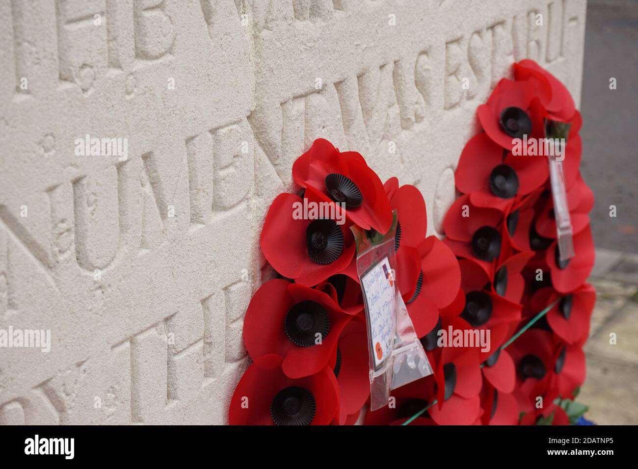 Remembrance day poppy wreathes on a war memorial to commemorate fallen servicemen in past conflicts Stock Photo