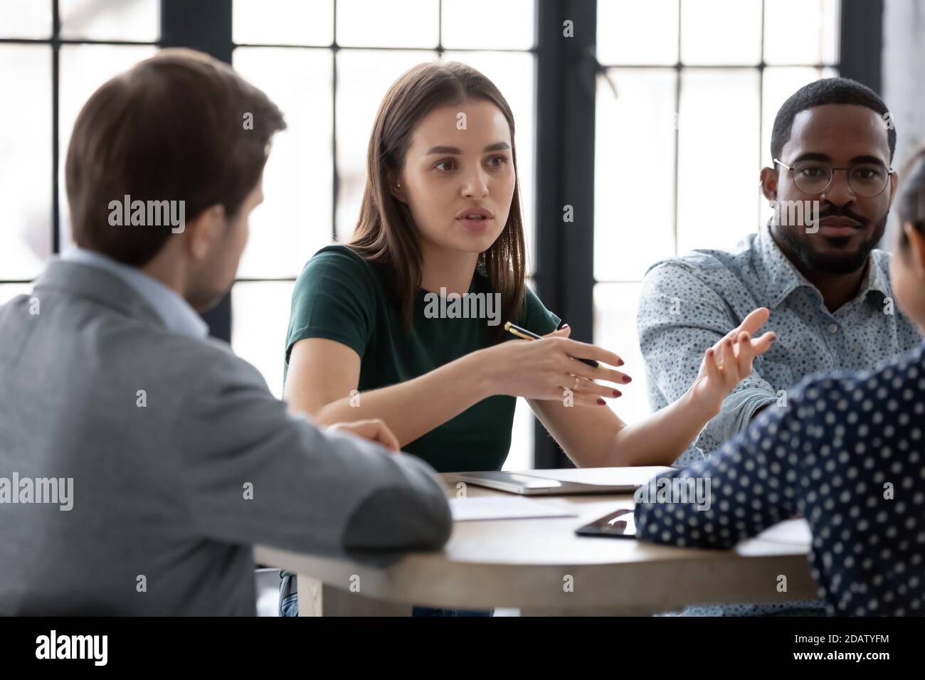 Two diverse groups of business partners sitting at negotiation table Stock Photo