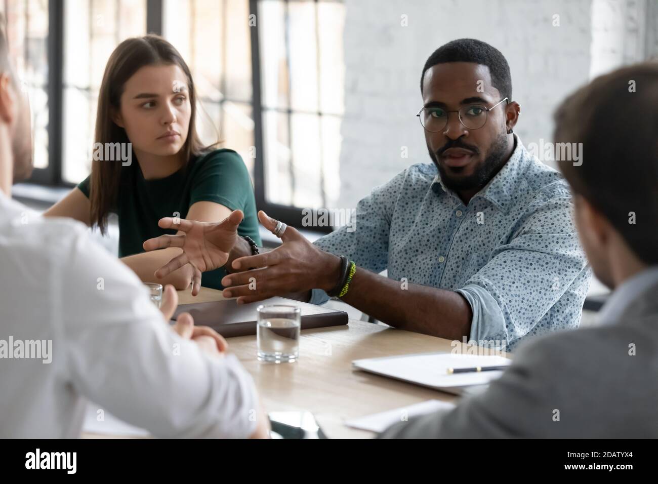 Black male consultant persuading group of clients in deal profit Stock Photo