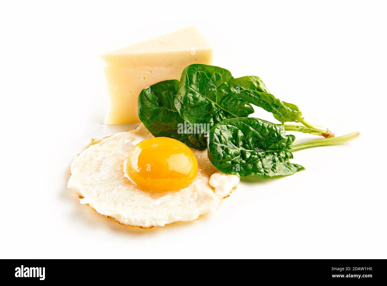 Fried egg, with spinach and cheese, over white background. Stock Photo