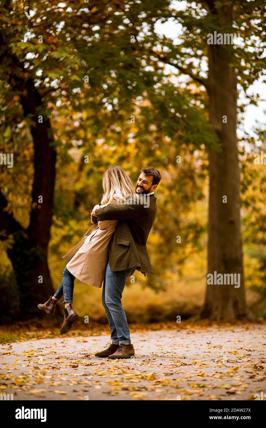 Handsome young couple having fun in the autumn park Stock Photo - Alamy
