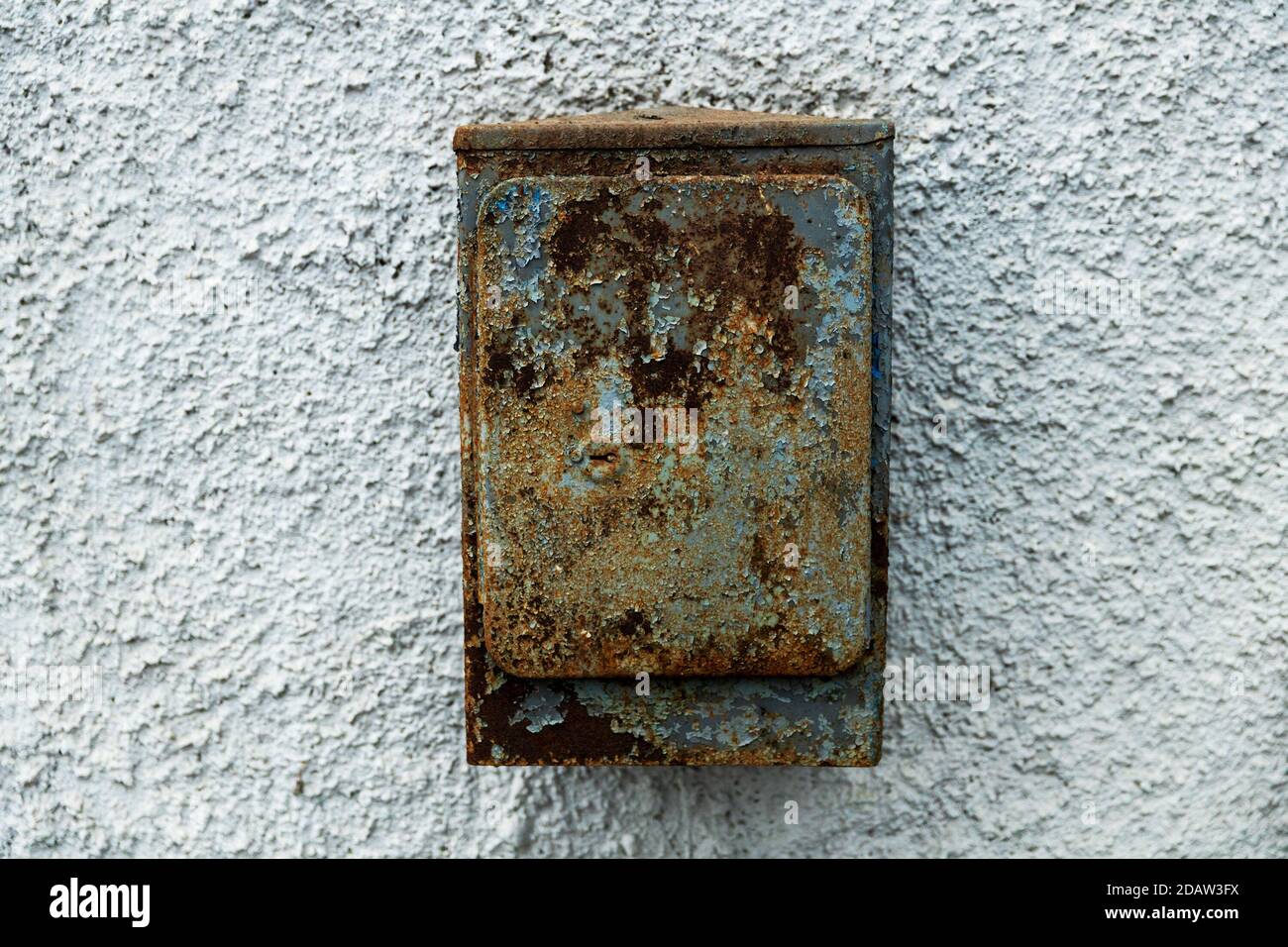 old rusty mailbox hanging on stone texture wall Stock Photo