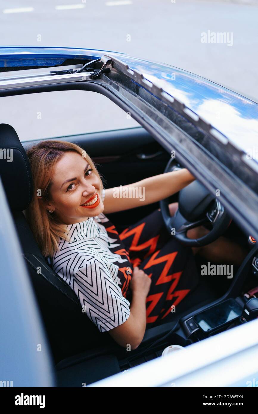 Young woman driving with sunroof open Stock Photo Alamy