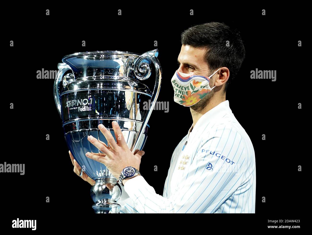 Novak Djokovic poses with his year end ATP number one trophy during day