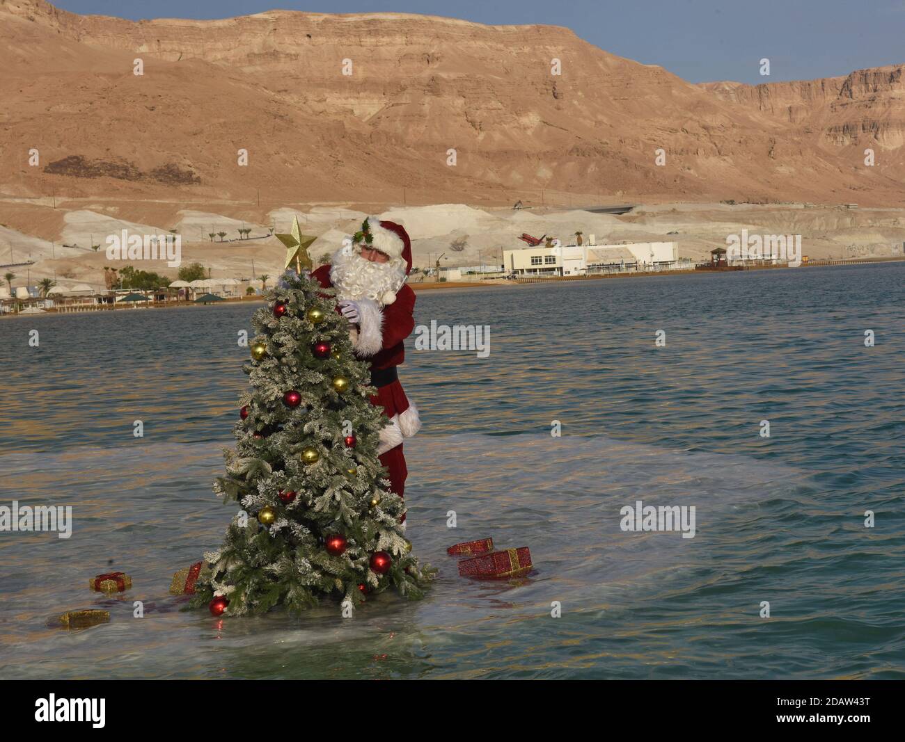 Ein Bokek, Israel. 15th Nov, 2020. Jerusalem Santa Issa Kassissieh decorates a Christmas tree on a salt formation in the Dead Sea, the lowest place earth, in Ein Bokek, Israel on Sunday, November 15, 2020. The photo event was organized by the Israel Ministry of Tourism to encourage tourism to the Dead Sea ahead of the Christmas holiday. Incoming tourism to Israel has received a severe blow due to the global coronavirus pandemic and the closure to incoming tourists since March. Photo by Debbie Hill/UPI Credit: UPI/Alamy Live News Stock Photo