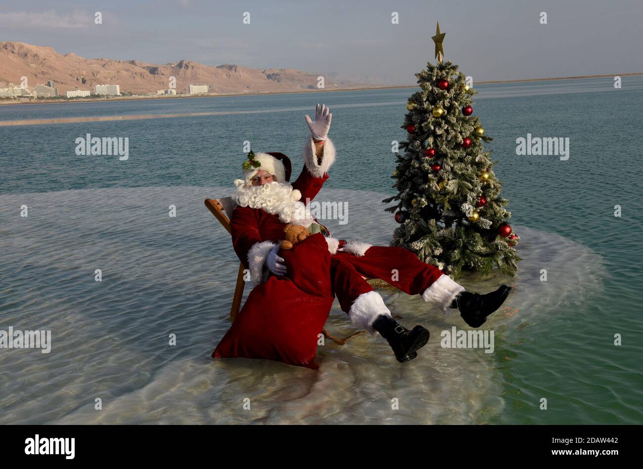 Ein Bokek, Israel. 15th Nov, 2020. Jerusalem Santa Issa Kassissieh waves from a salt formation in the Dead Sea, the lowest place earth, in Ein Bokek, Israel on Sunday, November 15, 2020. The photo event was organized by the Israel Ministry of Tourism to encourage tourism to the Dead Sea ahead of the Christmas holiday. Incoming tourism to Israel has received a severe blow due to the global coronavirus pandemic and the closure to incoming tourists since March. Photo by Debbie Hill/UPI Credit: UPI/Alamy Live News Stock Photo