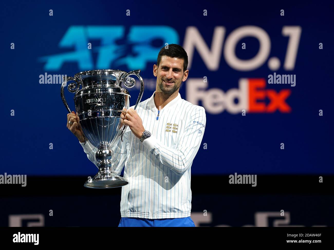 Novak Djokovic poses with his year end ATP number one trophy during day